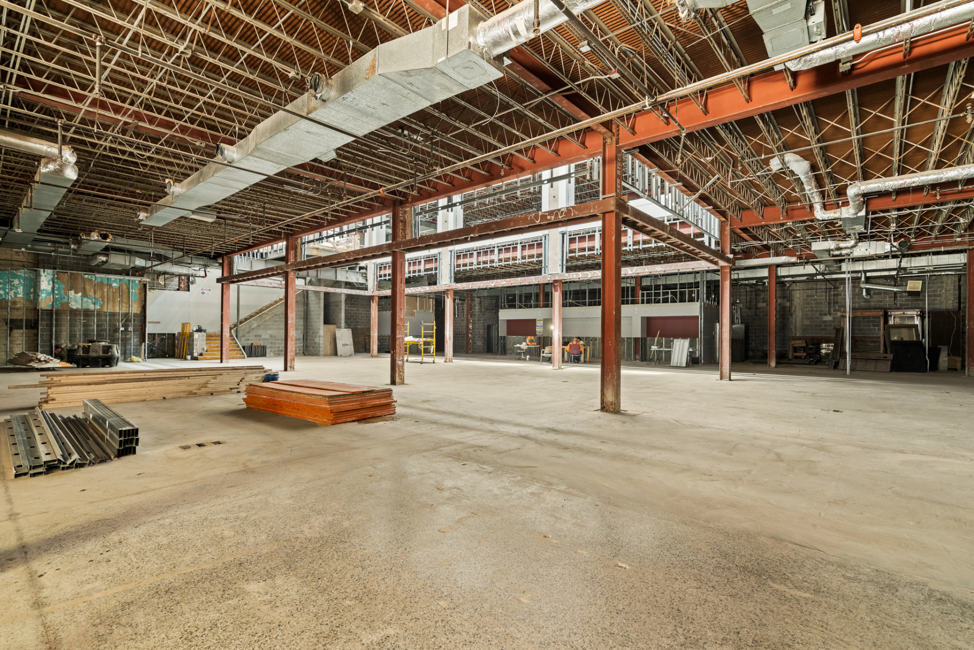 Commercial renovation progress with steel beams, ductwork, and interior framing
