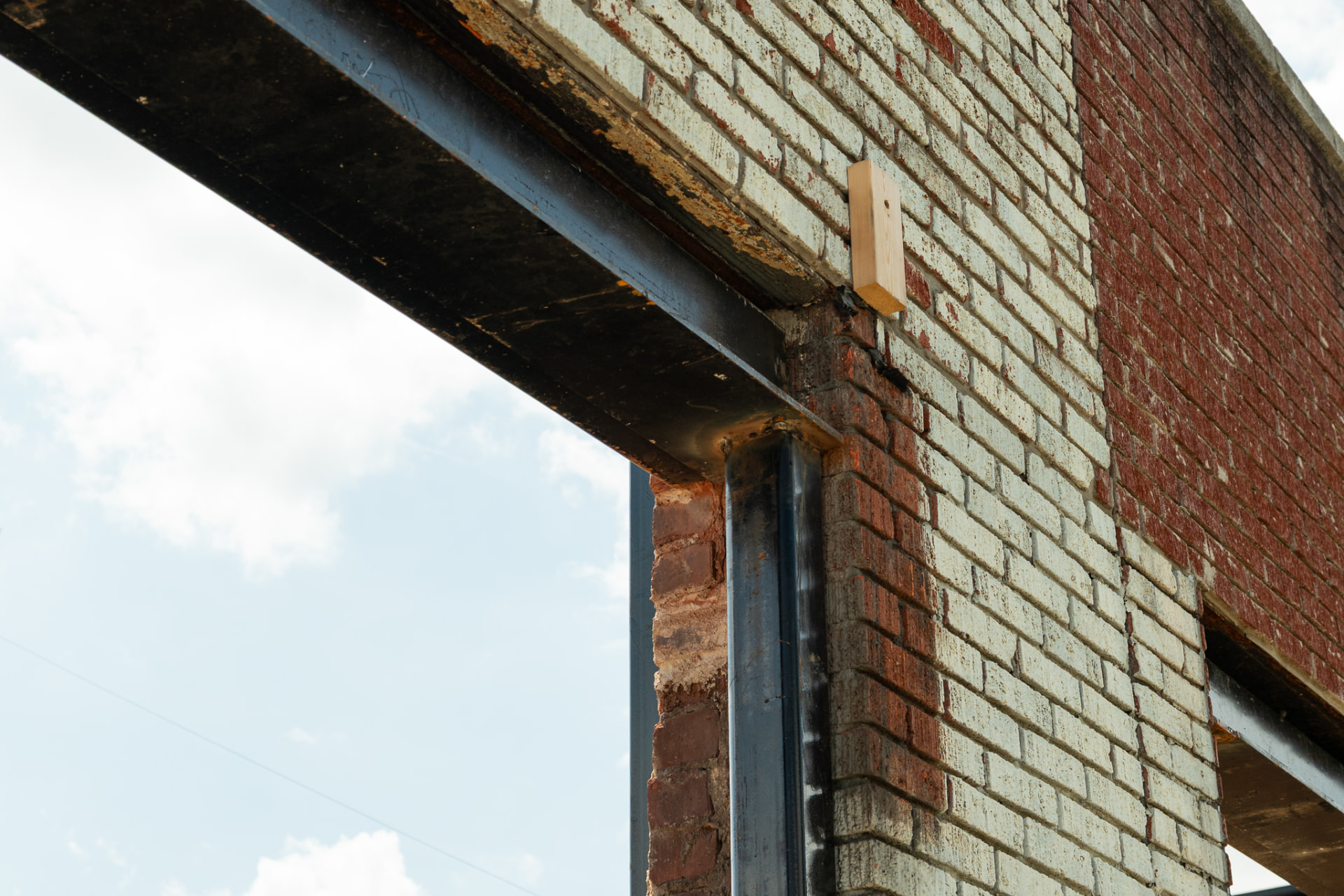 Close-up construction detail of structural steel joined to historic brick masonry