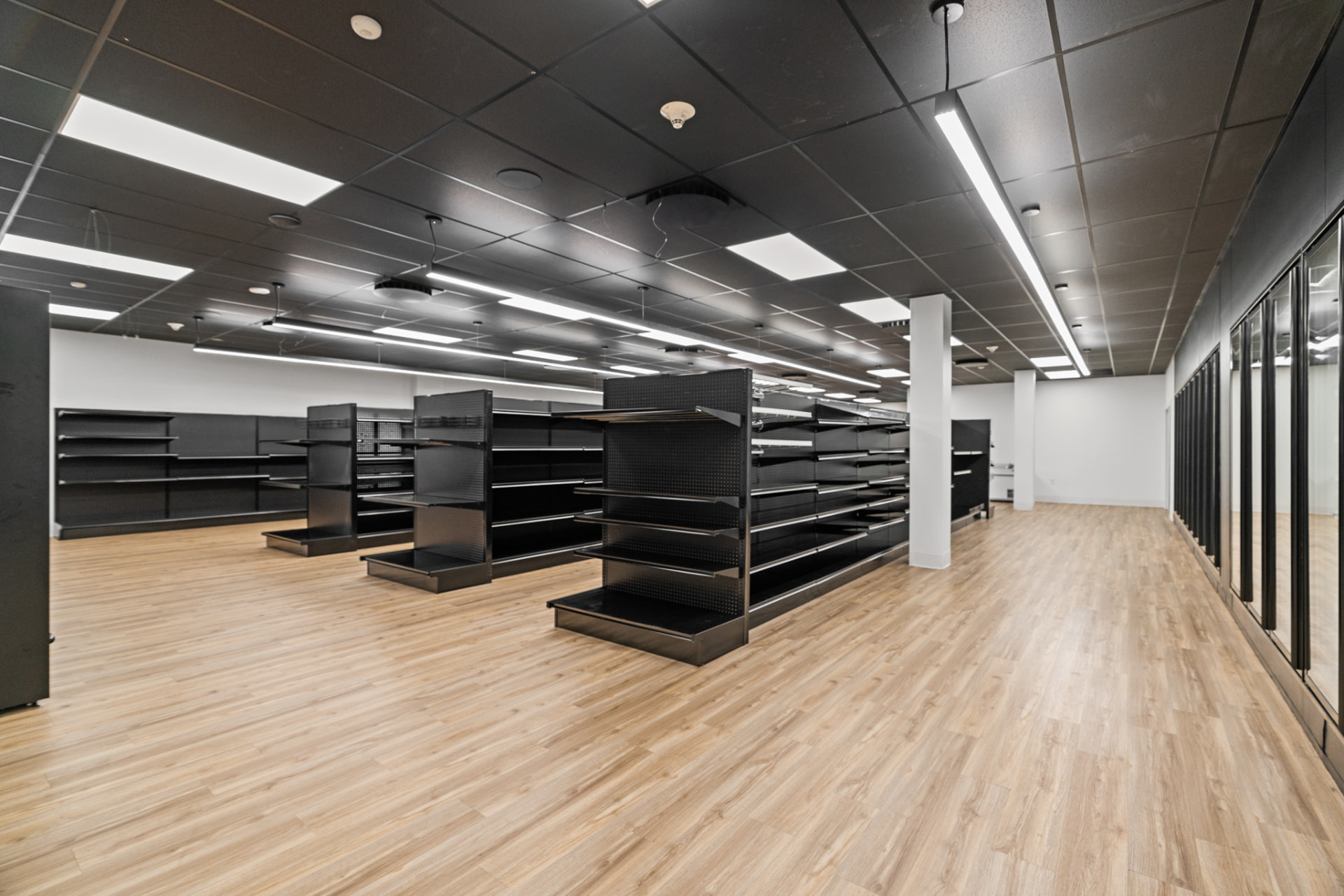 Flash-ambient photography of a finished commercial retail interior with shelving